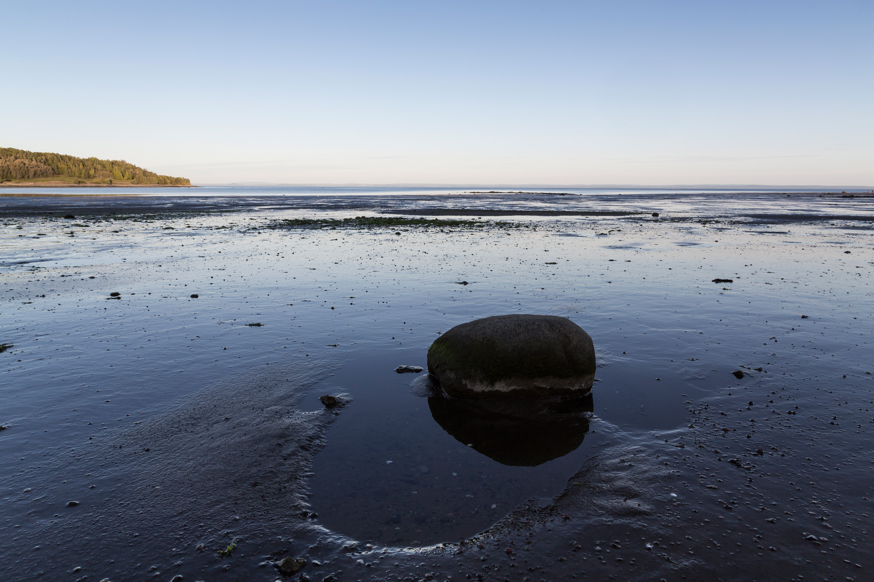 Une baie par marée basse laisse un estran exagérément luisant des reflets du crépuscule
