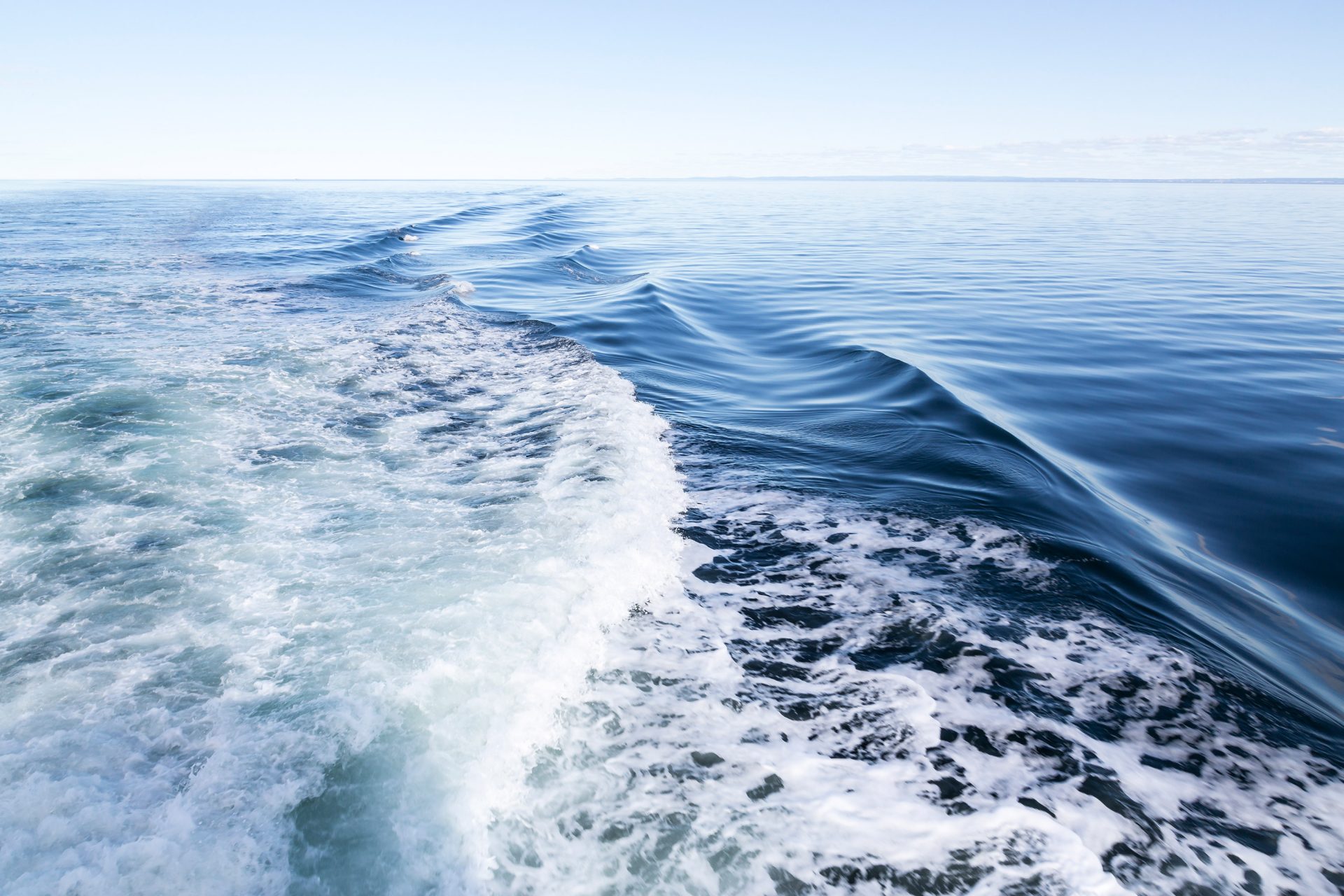 Une baie vaste et d'un bleu lumineux, dans le sillage d'un bateau